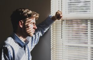 man standing facing window