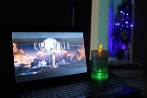 burning candle and open laptop