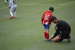 Man tying child's shoelaces