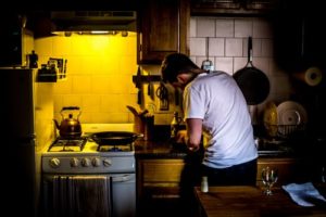 Man standing in kitchen.