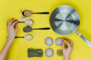 Saute skillet beside spoon of spices and vegetable