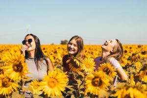 Women in a sunflower field, happy